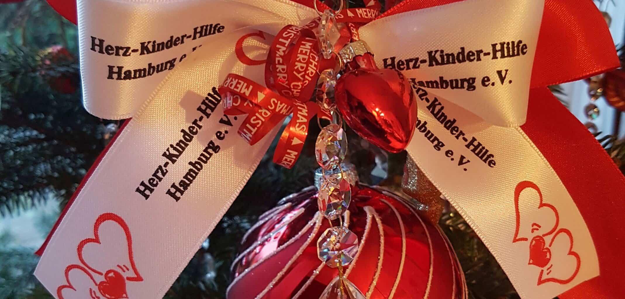 Rote Weihnachtsbaumkugel mit Schleife "Herz-Kinder-Hilfe"